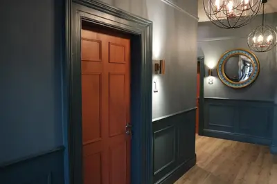 a hallway with a red door and a mirror at No 9 The Folly in Southport