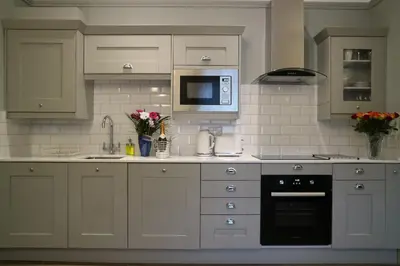 a kitchen with white cabinets and a sink and a microwave at No 9 The Folly in Southport