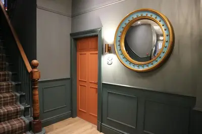 a hallway with a mirror on the wall next to a door at No 9 The Folly in Southport