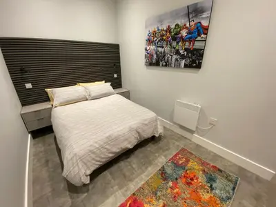 a bedroom with a bed and a painting on the wall at Kempston Suites Liverpool Apartment 1 in Liverpool