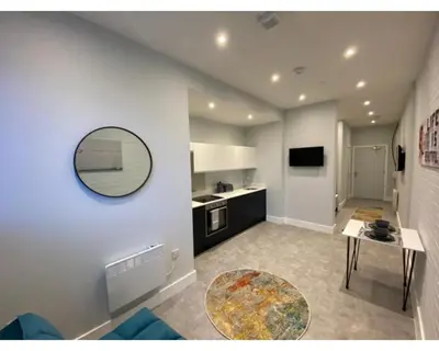 a living room with a table and a mirror on the wall at Kempston Suites Liverpool Apartment 5 in Liverpool