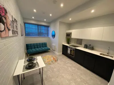 a kitchen with a blue couch in a room at Kempston Suites Liverpool Apartment 10 in Liverpool