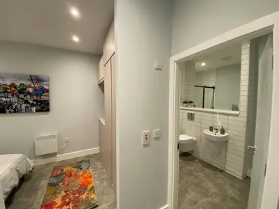 a bathroom with a bed and a sink and a mirror at Kempston Suites Liverpool Apartment 11 in Liverpool