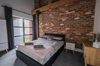 a bedroom with a brick wall and a bed at The Eden Warehouse - Green Apartment, sleeps 5 in Southport