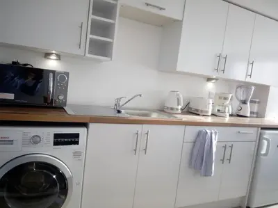 a kitchen with a washing machine and a sink at The Staithe by the Canal. in Lancaster