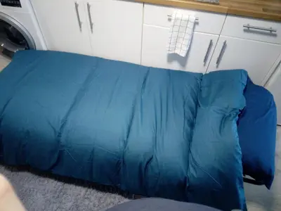 a blue couch in a kitchen with a washing machine at The Staithe by the Canal. in Lancaster
