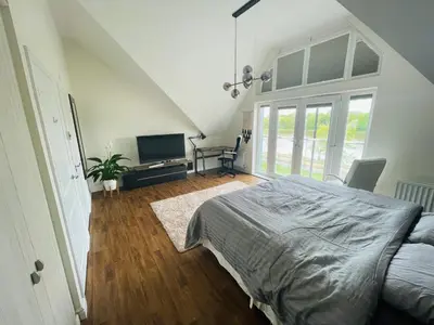 a bedroom with a bed and a television in it at Large En-Suite with Stunning River Views in Lancaster in Torrisholme