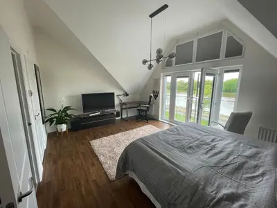 a bedroom with a bed and a flat screen tv at Large En-Suite with Stunning River Views in Lancaster in Torrisholme