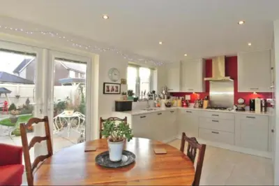 a kitchen with a wooden table with chairs and a dining room at Large En-Suite with Stunning River Views in Lancaster in Torrisholme