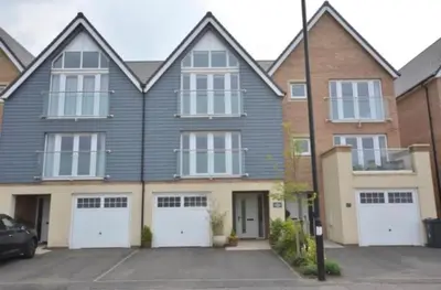 a large house with white garage doors in a parking lot at Large En-Suite with Stunning River Views in Lancaster in Torrisholme