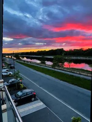 a car parked on the side of a road at sunset at Large En-Suite with Stunning River Views in Lancaster in Torrisholme