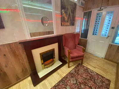 a living room with a chair and a fireplace at Mellory hotel in Blackpool