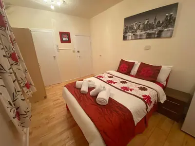 a bedroom with a large bed with red and white sheets at Mellory hotel in Blackpool