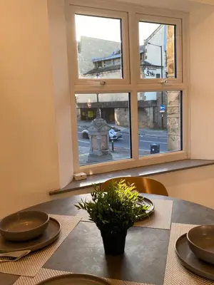 a table with two plates and a plant on a table with a window at Spacious City Centre Property in Lancaster
