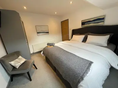a bedroom with a large bed and a chair at Spacious City Centre Property in Lancaster