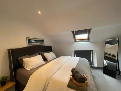 a bedroom with a large bed and a mirror at Spacious City Centre Property in Lancaster