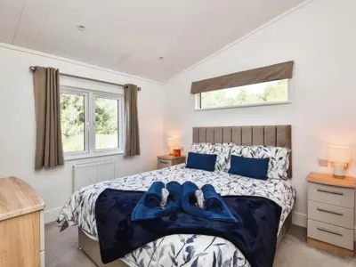 a bedroom with a bed with blue towels on it at Gerrida Lodge in Carnforth