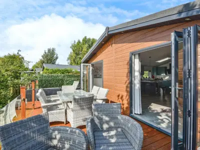 a patio with chairs and a table on a deck at Gerrida Lodge in Carnforth