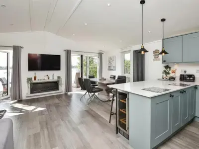 an open kitchen and dining room with a table and chairs at Gerrida Lodge in Carnforth