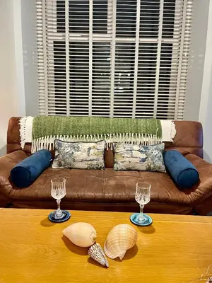 a living room with a couch with two glasses on a table at Beach Retreat in Lytham St Annes