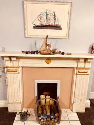 a fireplace with a boat on top of it at Beach Retreat in Lytham St Annes