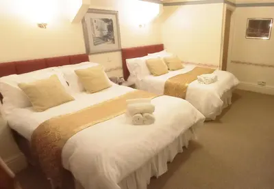 a hotel room with two beds with towels on them at Lily Hotel in Blackpool