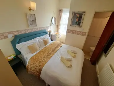 a bedroom with a bed with two towels on it at Lily Hotel in Blackpool