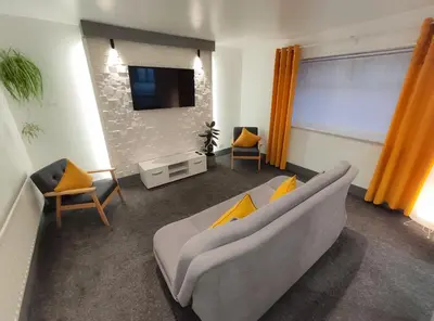 a living room with a couch and a tv at The Bawdens Holiday Apartments in Blackpool