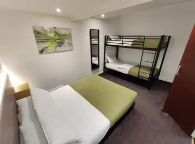 a bedroom with two bunk beds and a mirror at The Bawdens Holiday Apartments in Blackpool