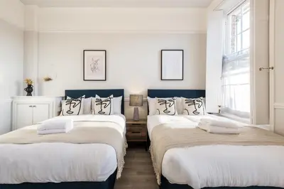 two beds in a room with white walls at Host & Stay - The Seel Street Townhouse in Liverpool