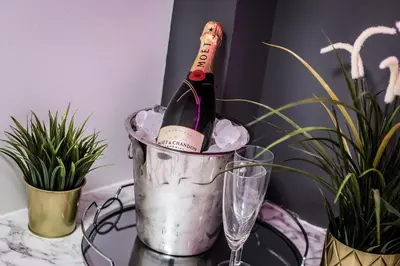 a bottle of wine in a bucket on a table with plants at Host & Stay - The Seel Street Townhouse in Liverpool