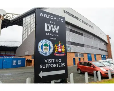 a sign in front of a building with a car at Stylish 3 bedroom house only 5 mins from M6/M58 in Wigan
