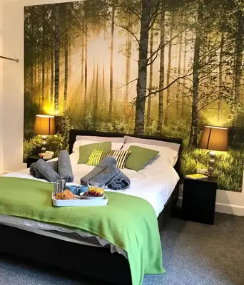 a bed with a tray of food on top of it at Stylish 3 bedroom house only 5 mins from M6/M58 in Wigan