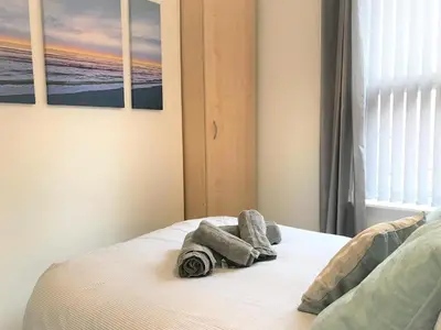 a bedroom with a bed with towels on it at Central Wigan welcoming Townhouse sleeps up to 6 in Wigan