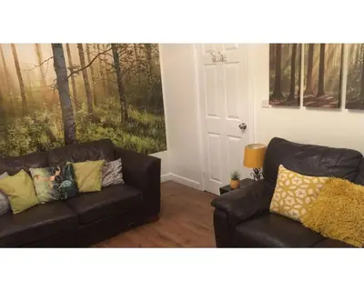 a living room with two leather couches and a door at Central Wigan welcoming Townhouse sleeps up to 6 in Wigan