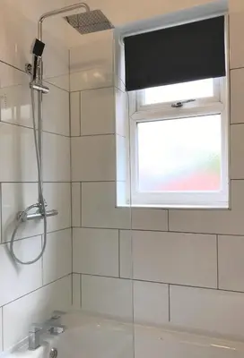 a bathroom with a shower and a sink and a window at Central Wigan welcoming Townhouse sleeps up to 6 in Wigan