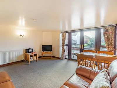 a living room with a couch and a television at The Barn in Poulton le Fylde