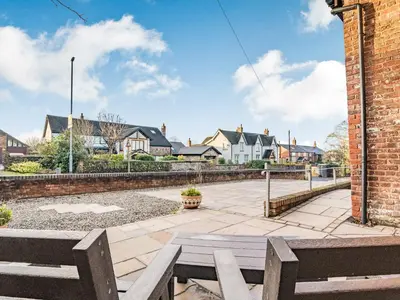 a park bench in a courtyard with houses in the background at The Barn in Poulton le Fylde
