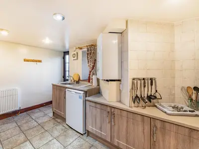 a kitchen with a sink and a refrigerator at The Barn in Poulton le Fylde