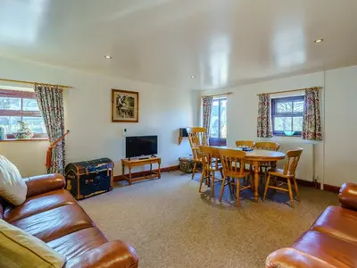 a living room with a couch and a table and chairs at The Shippon in Poulton le Fylde