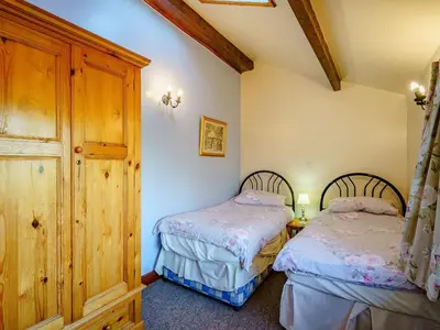 two beds in a room with wooden ceilings at The Shippon in Poulton le Fylde