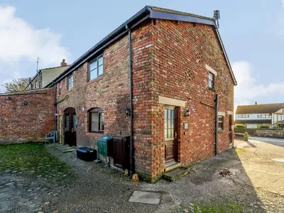 an old brick building with a door on the side at The Shippon in Poulton le Fylde