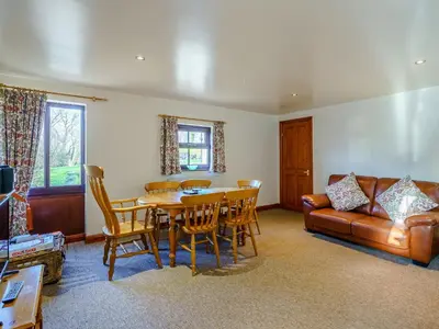 a living room with a table and a couch at The Shippon in Poulton le Fylde