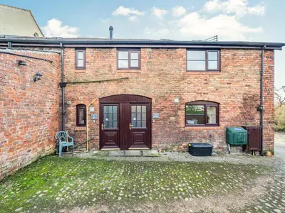 a brick building with a door and a yard at The Hay Loft in Poulton le Fylde