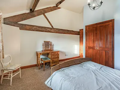 a bedroom with a bed and a desk and a chair at The Hay Loft in Poulton le Fylde