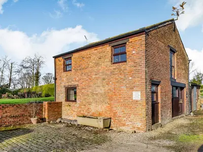 an old red brick building with a sky background at The Granary in Poulton le Fylde
