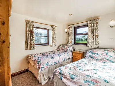 two beds in a room with two windows at The Granary in Poulton le Fylde