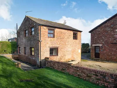 an old brick house with a stone wall at The Granary in Poulton le Fylde