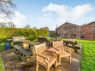 a patio with tables and chairs and a picnic table at The Granary in Poulton le Fylde
