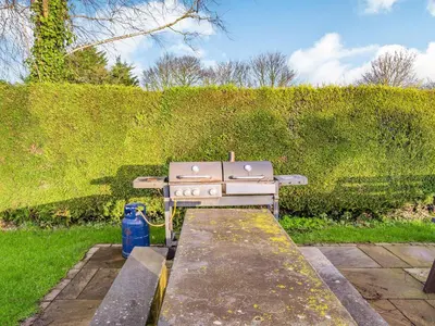a gas stove sitting on a stone slab in a garden at The Granary in Poulton le Fylde